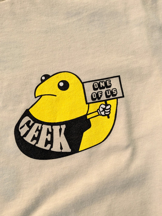 Beige fabric with a yellow and black graphic of a duck holding a sign and the word 'GEEK'.