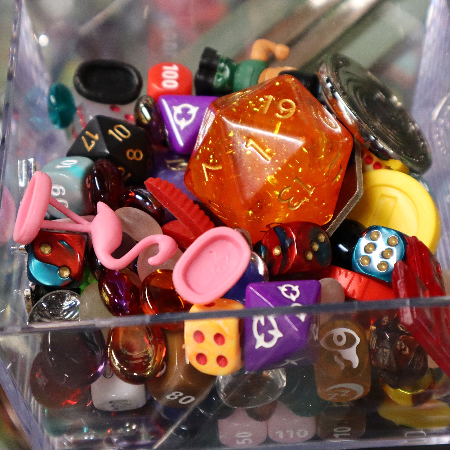 Close up of the grab bag dice and tricket boxes made by the geek peek. Showing mixture of dice and tokens.